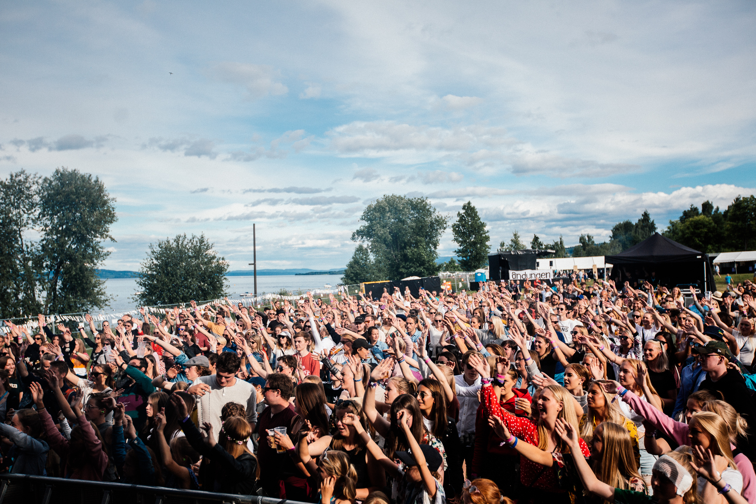 Bilde av folkemengde på festival med hendene i været 