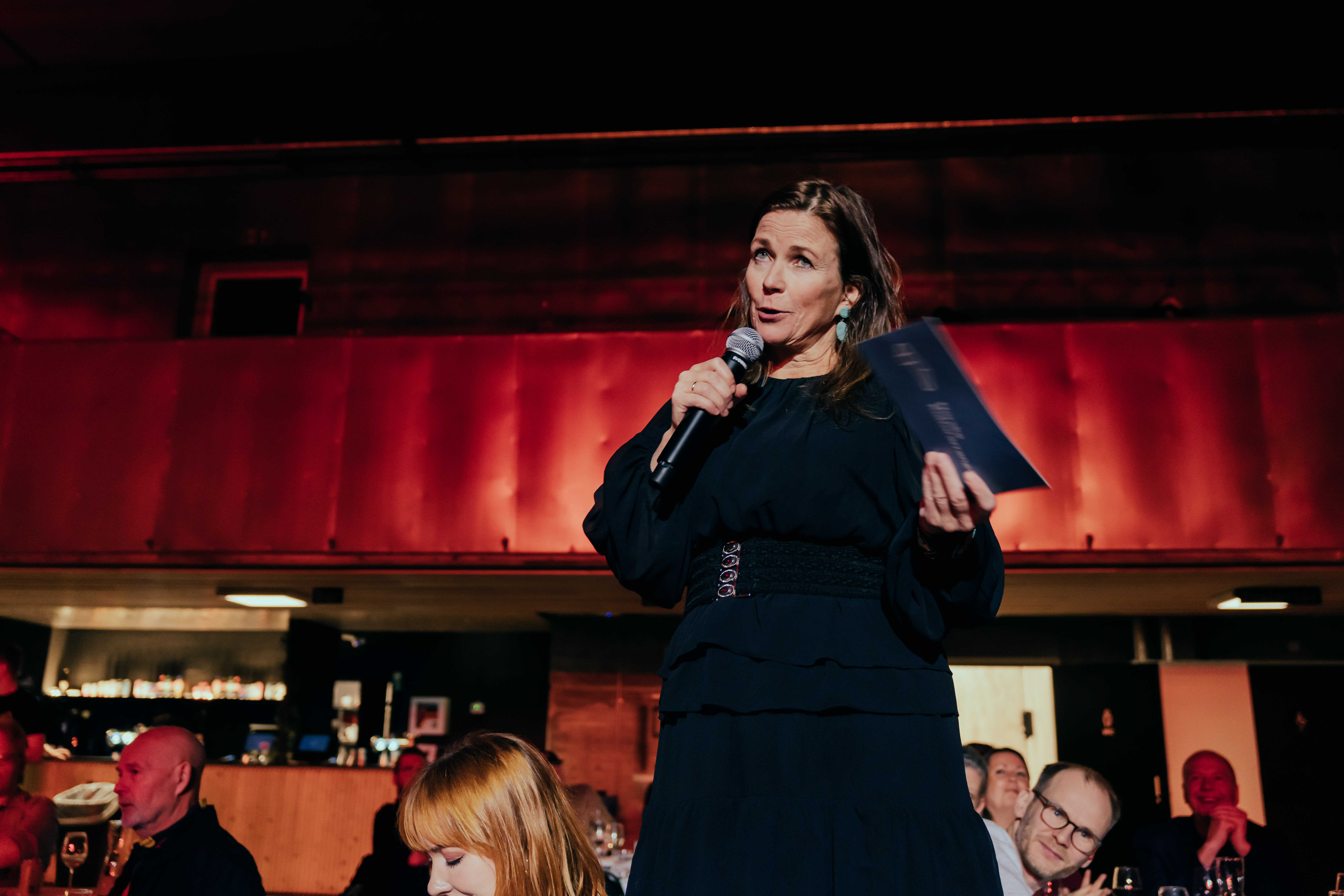 En festkledd vikarierende daglig leder, Trude Storheim, holder takketale under festmiddagen i Svømmehallen under årets Arrangørkonferanse. 