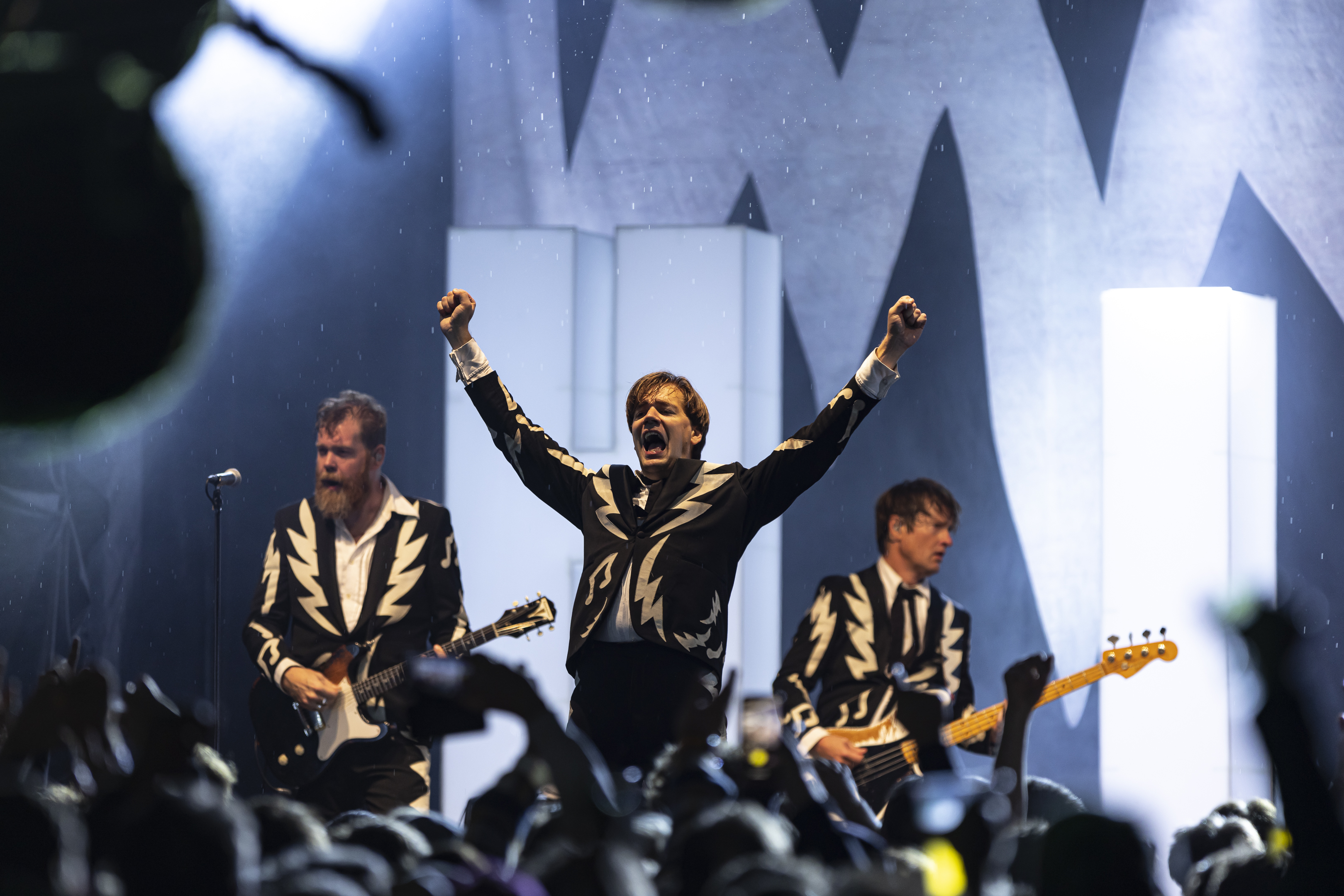 The Hives leverer et show med voldsom energi under en konsert på Foynhagen. Bandets frontfigur hever armene i jubel mot publikum. 