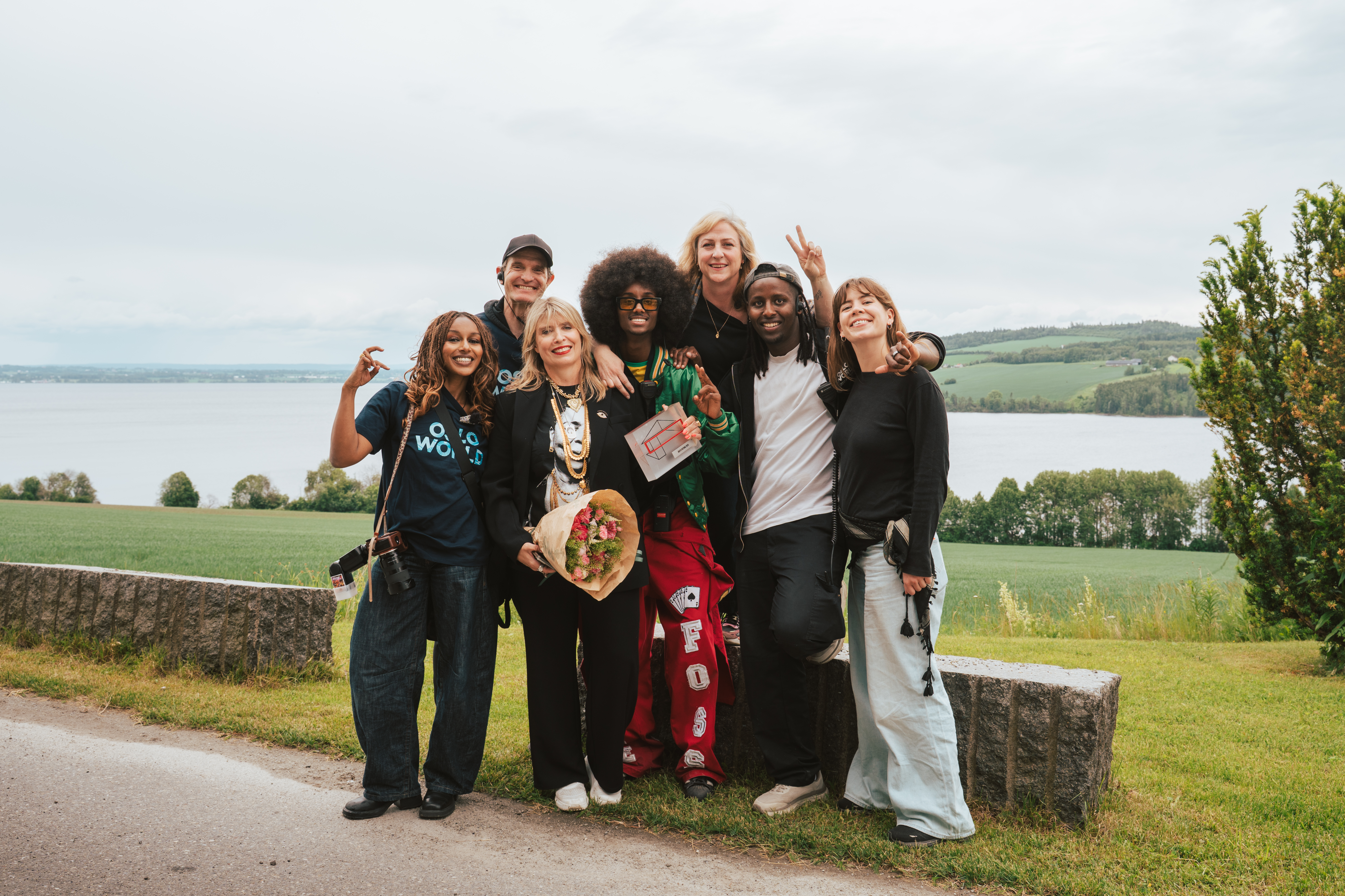 En gruppe mennesker smiler mot kamera i landlige omgivelser.