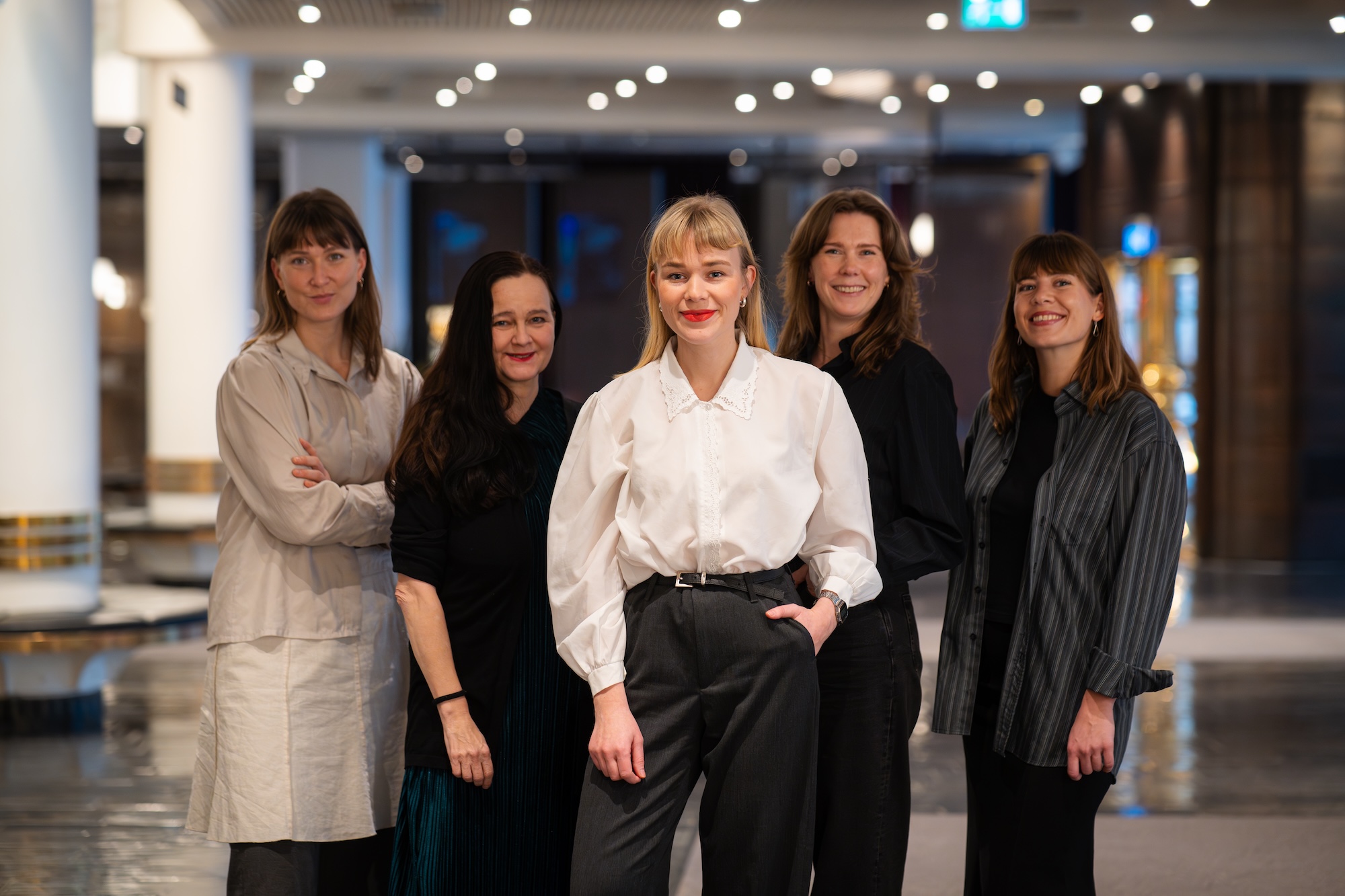 Fem kvinner står oppstilt og smiler til fotografen.